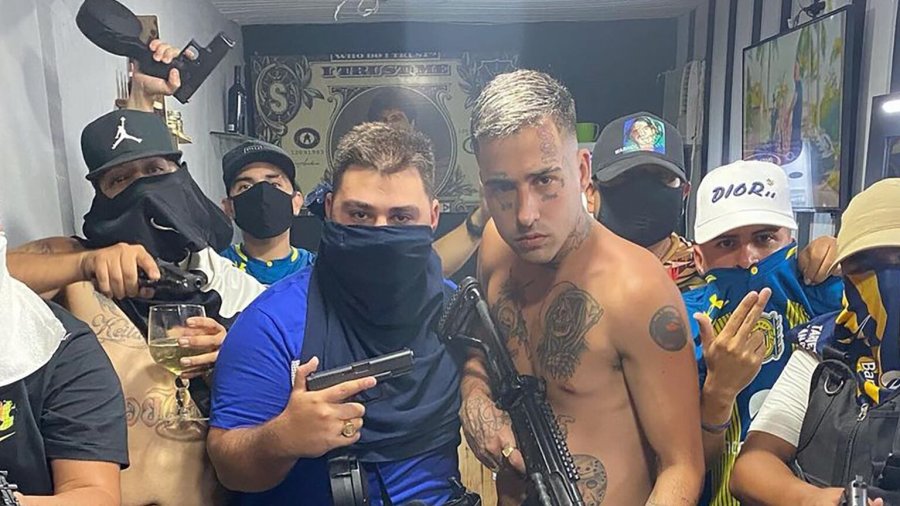 Samuel Medina con su cara tapada con una toalla azul junto al cantante de trap Zaramay